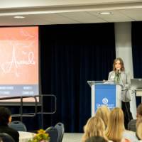 Woman at a podium speaking to a crowd